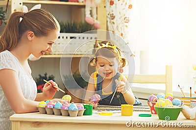 Happy family mother and child girl paints eggs for Easter Stock Photo