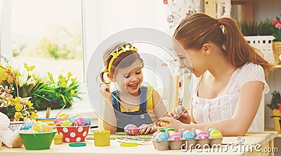 Happy family mother and child girl paints eggs for Easter Stock Photo