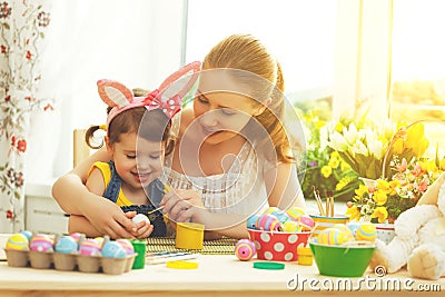 Happy family mother and child girl paints eggs for Easter Stock Photo