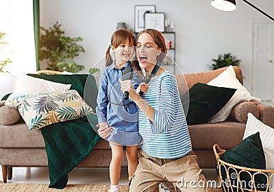Happy family mother and child play at home and sing with combs Stock Photo