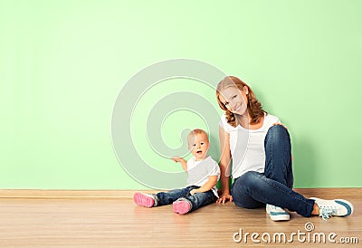 happy family of mother and child sitting on the floor in an empty wall Stock Photo