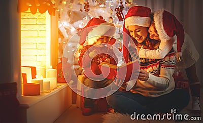 Family mother and children read a book at christmas near firep Stock Photo