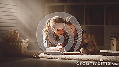 Happy family mother and daughter read a book in evening Stock Photo