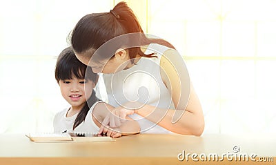 Happy family mother and daughter read a book at home Stock Photo