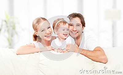 Happy family mother, father, child baby daughter at home on sofa playing and laughing Stock Photo