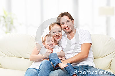 Happy family mother, father, child baby daughter at home on sofa playing and laughing Stock Photo