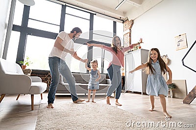 Happy family mother father and child daughter dancing at home. Stock Photo