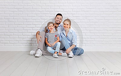 Happy family mother father and child near an empty brick wall Stock Photo