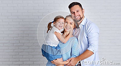 Happy family mother father and child near an empty brick wall Stock Photo