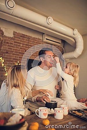 Happy family - Mother, father and daughter play and cook Christmas cookies in the loft-style kitchen Stock Photo