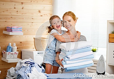 Happy family mother housewife and child daughter ironing clothes Stock Photo