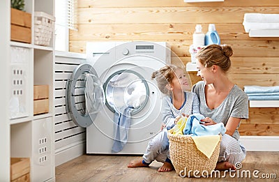 Happy family mother housewife and child in laundry with washin Stock Photo