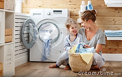 Happy family mother housewife and child in laundry with washin Stock Photo