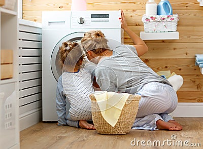 Happy family mother housewife and child in laundry with washin Stock Photo