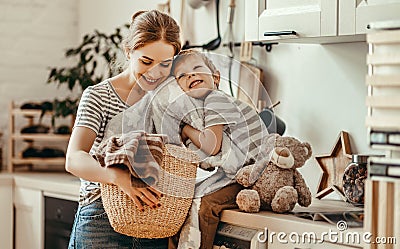 Happy family mother housewife and child in laundry with washing machine Stock Photo