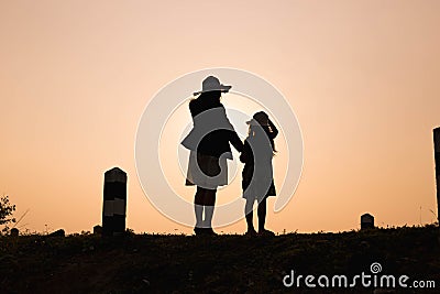 Happy family. A mother and son playing in grass fields outdoors at evening silhouette.Vintage Tone and copy space Stock Photo