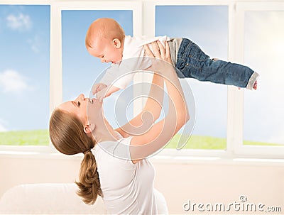 Happy family. Mother throws up baby, playing Stock Photo