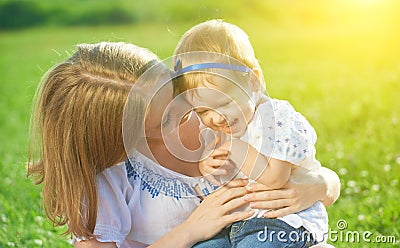 Happy family on nature mother tickle baby daughter and laugh Stock Photo