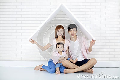 Happy family in new house with roof Stock Photo