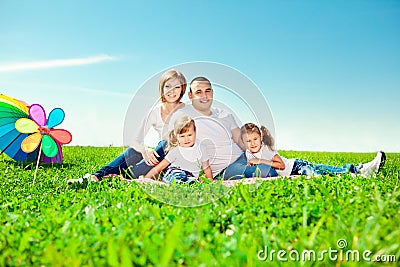 Happy family in outdoor park at sunny day. Mom, dad and two dau Stock Photo