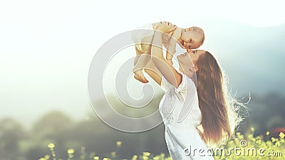 happy family outdoors. mother throws baby up, laughing and playing in summer on nature Stock Photo