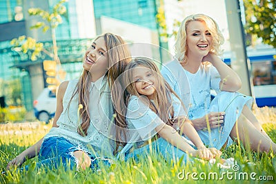 Happy Family photo. Closeup portrait photo toothy smiling two cute girls, her mother three members family just women on grass Stock Photo