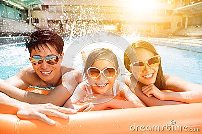 Happy family playing in swimming pool Stock Photo