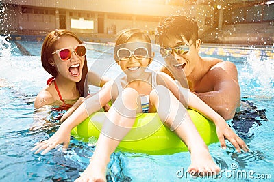 Happy family playing in swimming pool Stock Photo