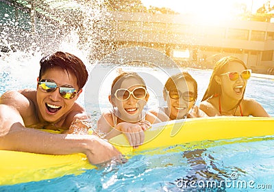 Happy family playing in swimming pool Stock Photo