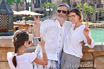 Happy family posing in city. girl taking picture of parents Stock Photo