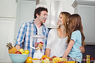 Happy family preparing fruit juice at table Stock Photo