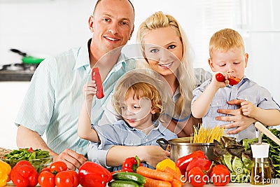 Happy family preparing a healthy dinner at home. Stock Photo