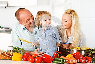 Happy family preparing a healthy dinner at home. Stock Photo