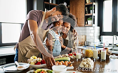 Happy family preparing healthy food in kitchen together Stock Photo