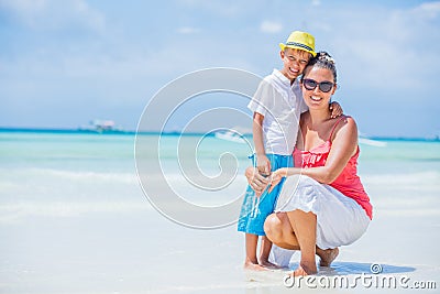 Happy family resting at beach in summer. Mother with boy resting on the beach. Young mother and her adorable little son Stock Photo
