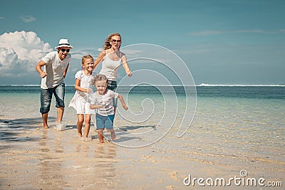 Happy family running on the beach Stock Photo