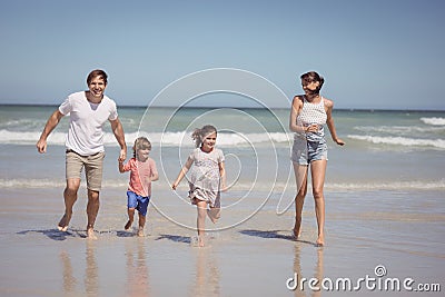 Happy family running on shore at beach Stock Photo