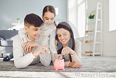 Happy family saves money in a piggy bank pig. Stock Photo