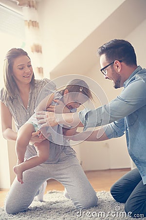 Happy family sitting on floor with their little baby. Stock Photo