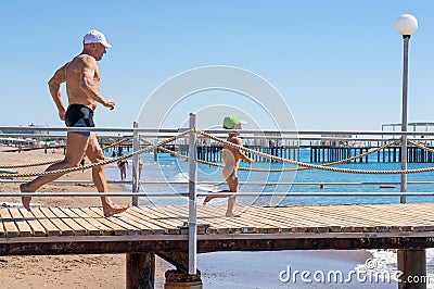 Happy family. Smiling grandfather and grandson playing at the sea. Running to the wave. Positive human emotions, feelings, Stock Photo