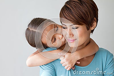 Happy family with smiling, positive daughter kissing her mother' Stock Photo