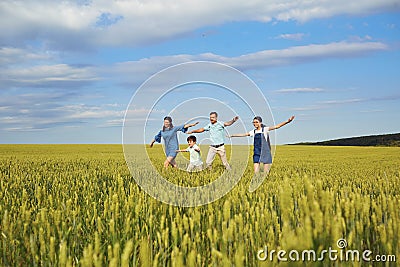 Happy family smiling running on the field in nature Stock Photo