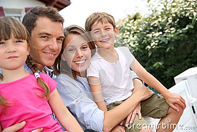 Happy family standing outside home Stock Photo