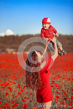Happy family summer vacation. Mother playing with son in poppies Stock Photo