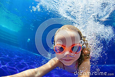 Funny child in goggles dive in swimming pool Stock Photo