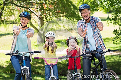 Happy family on their bike with thumbs up at the park Stock Photo