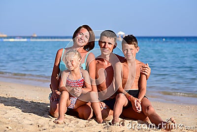 Happy family with two kids at the beach Stock Photo