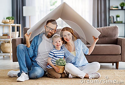 Happy family under fake roof in living room Stock Photo