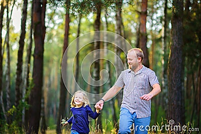 Happy family walks in the evening park, holding hands Stock Photo
