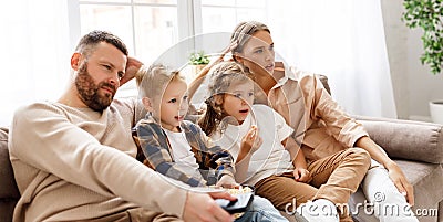 Happy family watching an exciting action-Packed movie on TV together Stock Photo